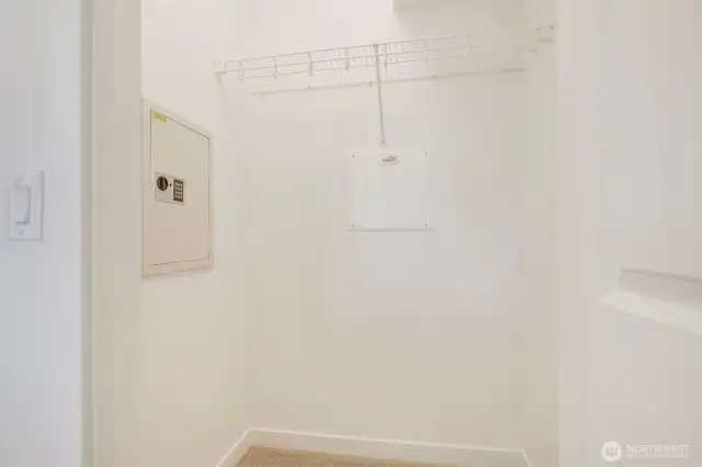 Walk-in closet with electronic wall safe.