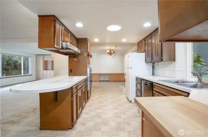 Large kitchen with loads of counter space & storage. Beyond is the kitchen dinette area with built- in buffet.