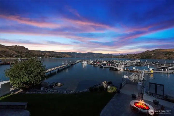 Looking from the upper level in the evenings overlooking the patio with fire pit and marina.