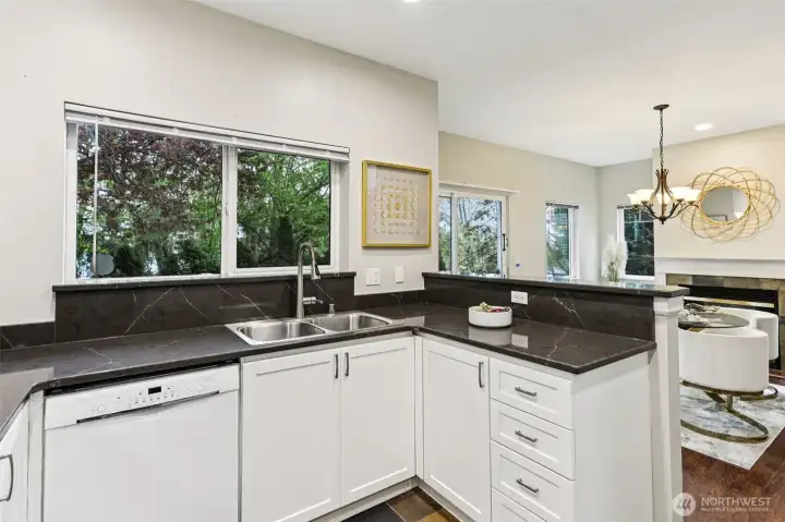 Bright, functional kitchen with generous counter space and a seamless connection to the dining and living areas—perfect for entertaining while enjoying peaceful, tree-lined views.