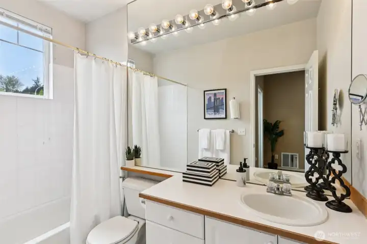 Upstairs guest bath with a full tub/shower combo, extended vanity space, and easy access to nearby bedroom and loft area.