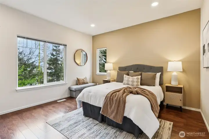 Oversized primary bedroom with abundant natural light and a relaxing atmosphere