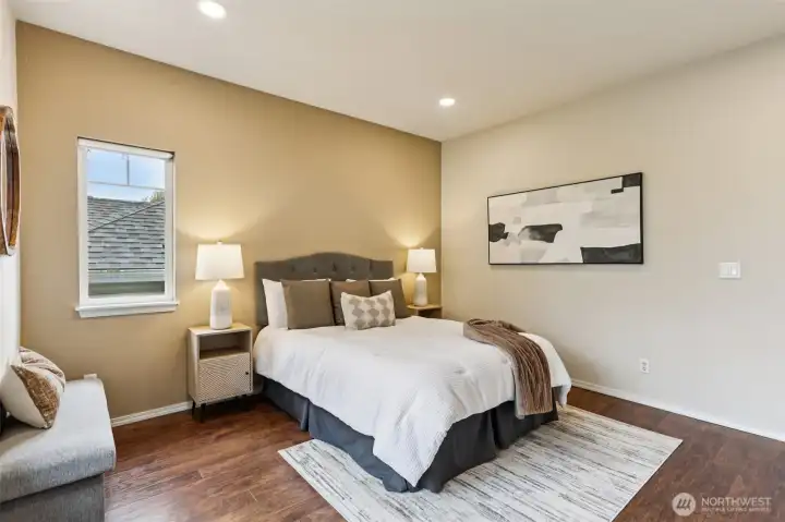 Inviting primary bedroom with warm tones, updated flooring, and a clean, modern feel—perfect for unwinding at the end of the day.