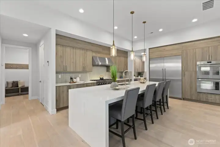 A dramatic waterfall island, professional-grade range, and curated finishes come together in a kitchen that feels every bit as beautiful as it is high-performing.