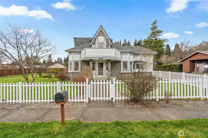 Charming Montesano farmhouse with white picket fence, wide streets, and sidewalks—situated on a spacious double corner lot in a quiet Grays Harbor neighborhood.