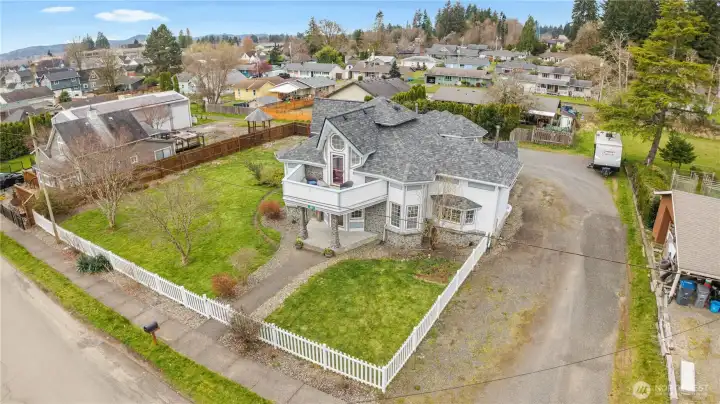 Aerial view of this Montesano WA farmhouse highlighting large corner lot, fenced yard, RV parking, and ideal proximity to schools, parks, and coastal access.