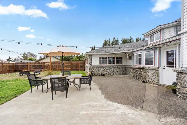 Outdoor entertaining space with seating area and fully fenced yard—perfect for pets and play.