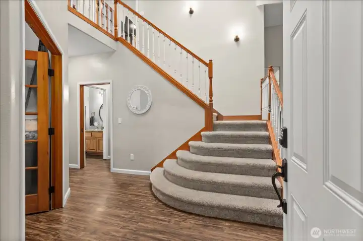 A welcoming entry sets the tone with soaring ceilings, an open staircase, and a layout that immediately feels both spacious and inviting.