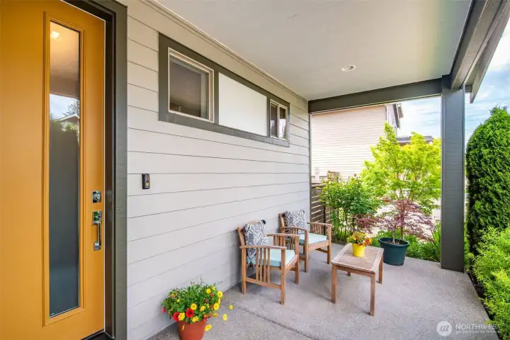 Covered front porch is perfect for evening chats surrounded by sweet smelling roses