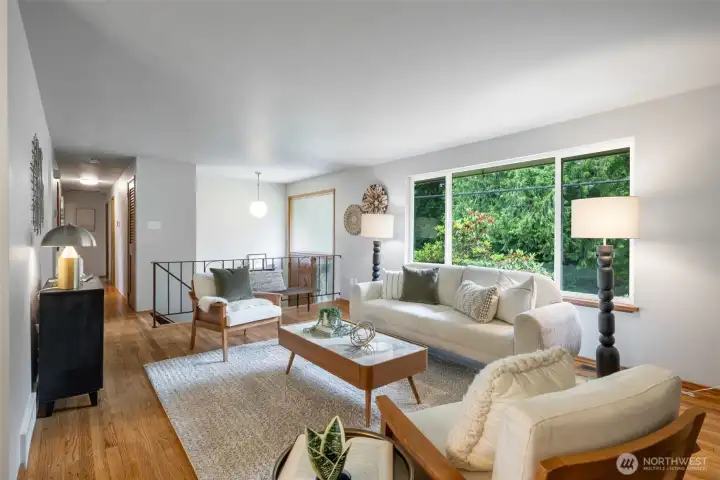 Bright living room with a large front window that floods the room with natural light.