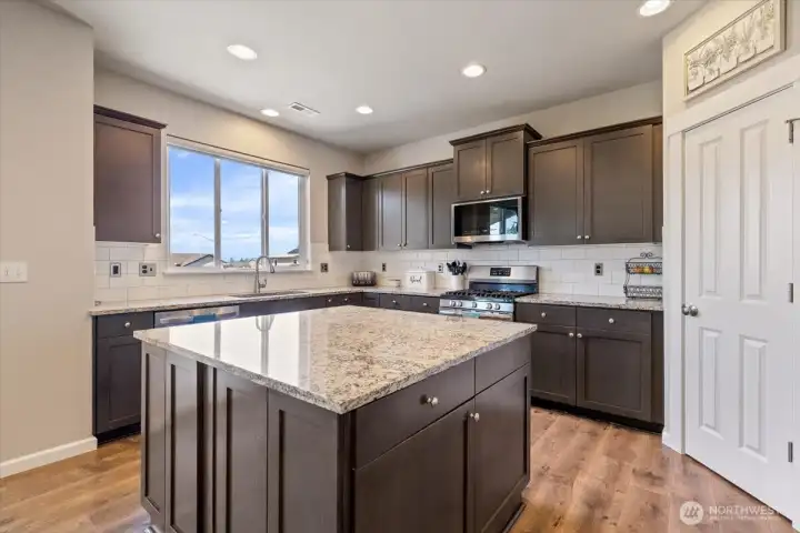 Closer picture of this well appointed kitchen. Nice sized Granite countered Island with cabinetry. Pantry, tile backsplash, and top of the line appliances!!