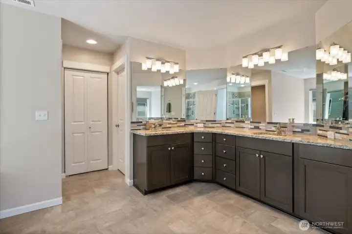 Dual vanity with plenty of counter space in primary bathroom! Nice finish work with granite counters and tile backsplash!