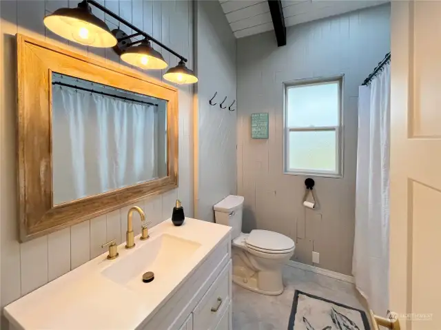 Upper level bath is just steps to both upper level bedrooms and has been cosmetically updated.  New floor, vanity, mirror, lighting, toilet & paint.