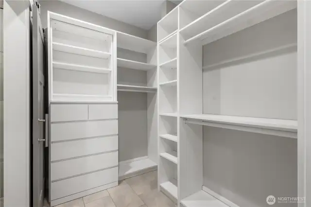 Walk-in closet with organizers in the main-floor primary suite.