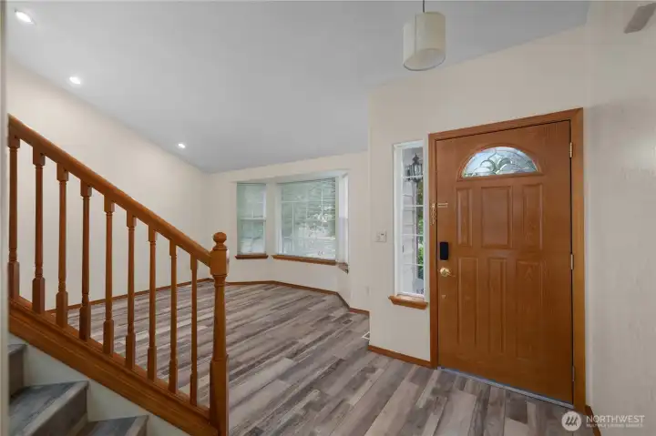 Just inside the front door, a living room with vaulted ceilings offers a beautiful, sunlit spot to relax.
