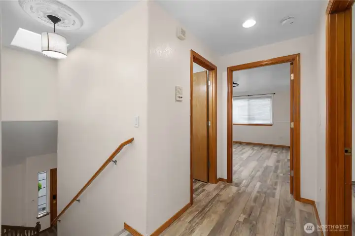 Upper level hallway leading to the primary suite, 3 additional bedrooms, and the hallway bathroom.