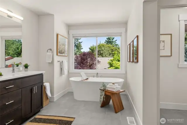 Free standing soaker tub, fully tiled bathroom.