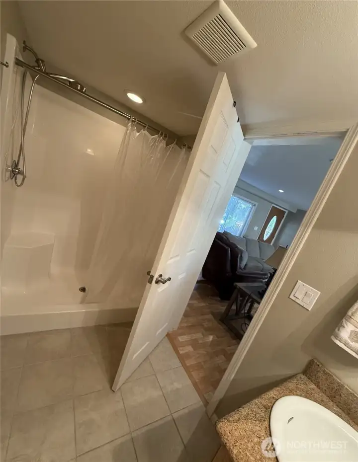 Big walk in shower, ceramic tile floor and granite countertop.