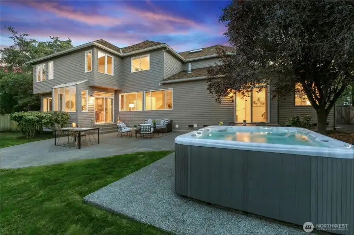 Fully fenced backyard is a private haven with a flat lawn, expansive patio, garden area, and soothing hot tub - perfect for year-round entertaining