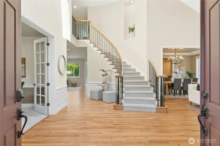 Grand entry with soaring ceilings, dramatic staircase, and exquisite lighting sets the tone for this luxurious home.