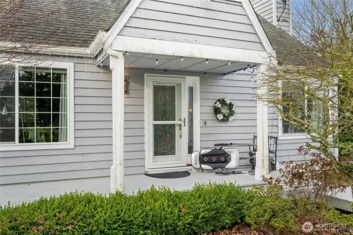 Covered porch entry with an ornate front door.