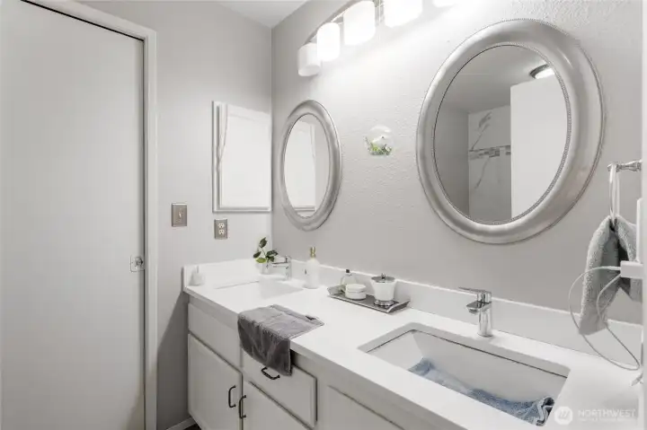 Main floor full bathroom with dual sinks; the pocket door on the left flows through the walk-in closet to the Primary bedroom...on the main floor!