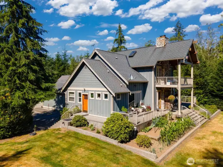 The home looks out toward a large level lawn surrounded by wildlife and forested land with walking trails throughout.