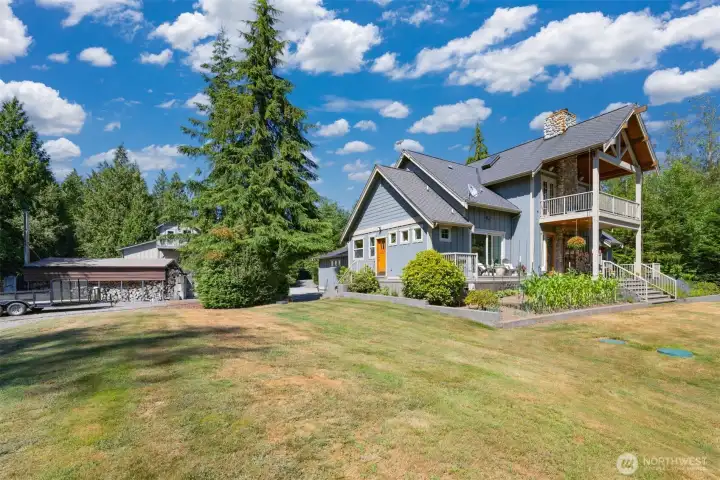 Looking back toward the rear elevation of the home with the wood storage building and the shop beyond.