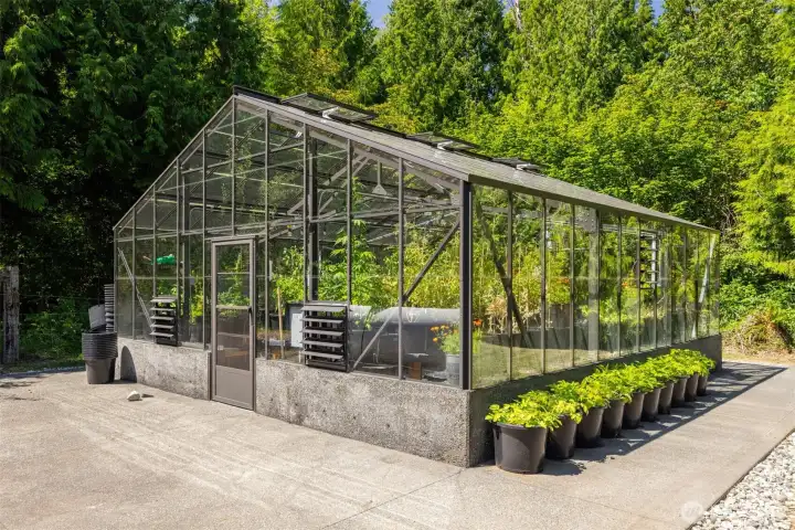 The 550 sf green house has automatic louvered windows and an industrial fan.