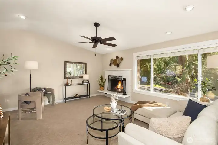 Inviting, sunlit family room with vaulted ceiling and large picture windows