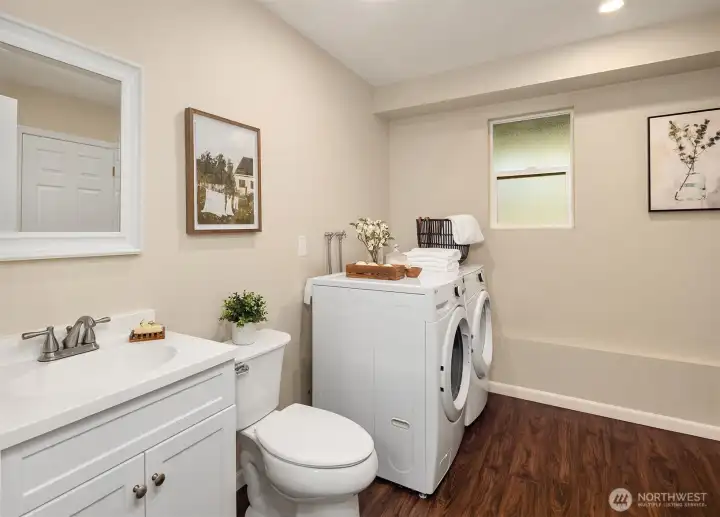 Lower-level half bath and utility room is accessible from the hallway or flex room