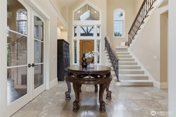 The grand travertine entry is impressive, yet welcoming with stained glass windows above the front door