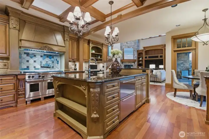 The kitchen is anchored by a large central island. Note the craftsmanship in the design and build with custom cabinetry, box ceilings and hood.  Wolf range, Subzero fridge Wolf range with pot filler, Subzero fridge (not shown),and additional under counter refridgeration drawers