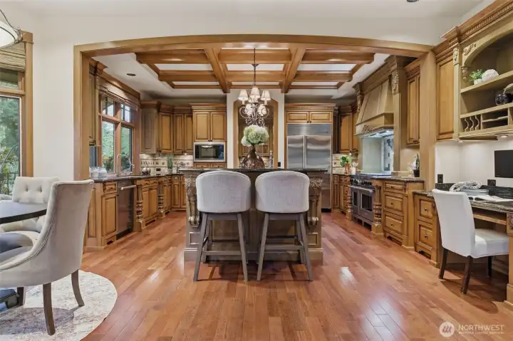 The kitchen is anchored by a large central island providing abundant food preparation space. There's a raised bar at the, a great landing spot for family and friends to gather. A planning station to the left is a nice touch.