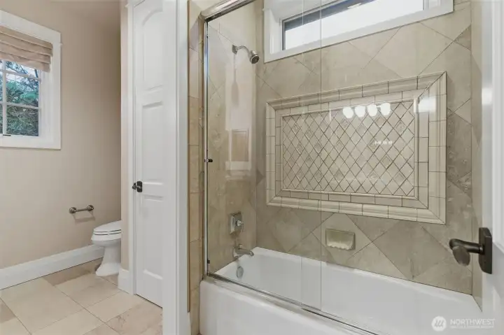 This full bathroom is shared by just two bedrooms, but each has their own private vanity.