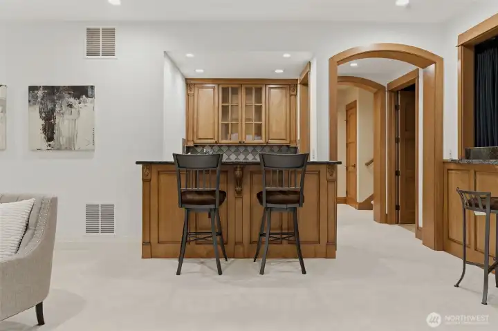 The lower level game room features a small second kitchen for convenience with sink, dishwasher and microwave