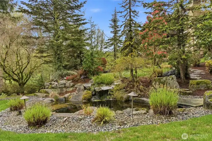 The beautifully landscaped yard includes a water feature that includes a natural looking stream flowing into the pond. It's really very tranquil and relaxing to hear the stream gurgling from both terraces and the balcony just off the office
