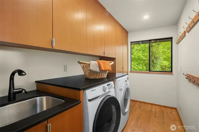Convenient mud/laundry room with custom soundproof door so you won't hear the washer and dryer! Don’t miss the shoe cubbies in the custom cabinetry.
