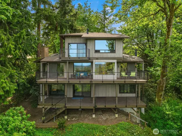 A view of the back of the home offering three decks and windows showcasing incredible views from all three levels.