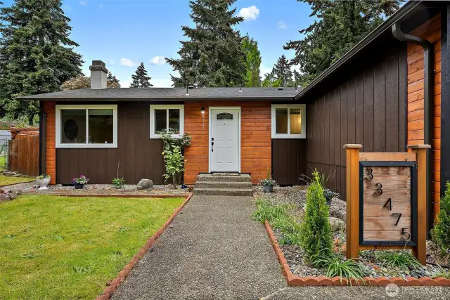 From the moment you arrive, this home feels special. The unique address sign, fresh landscaping, and cheerful entry path create a warm welcome every time you pull into the drive.