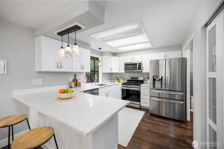 Kitchen with quartz countertops, stainless steal appliances and gas range.