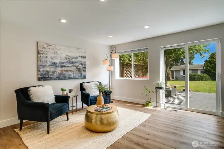 A lounge area perfect for another dining spot or cozy family room adjoins the kitchen. Sliding glass doors open to the deck and fenced back yard.