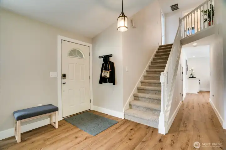 Now that we've seen a preview of the main floor, let's start at the beginning and see it all. The front door opens from the covered front porch to this entry area. The open staircase leads up to a full bath and the 3 bedrooms, including the primary suite. But for now, start with a visit to the living room.