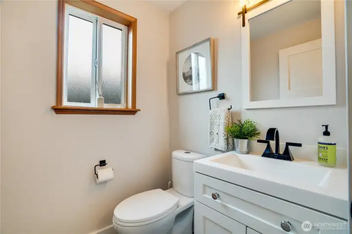 Take the door in the hall behind the kitchen into this half bath tucked beside the laundry area for privacy.