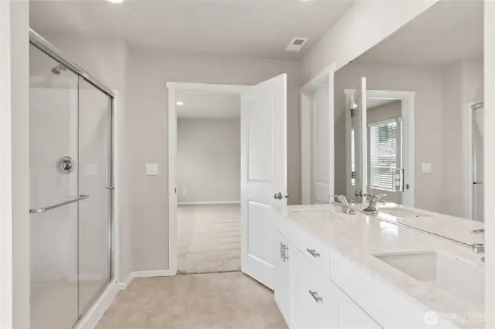 view of the large primary bathroom with quartz countertops.  hotos are representative only and may display different color package and/or upgrades.