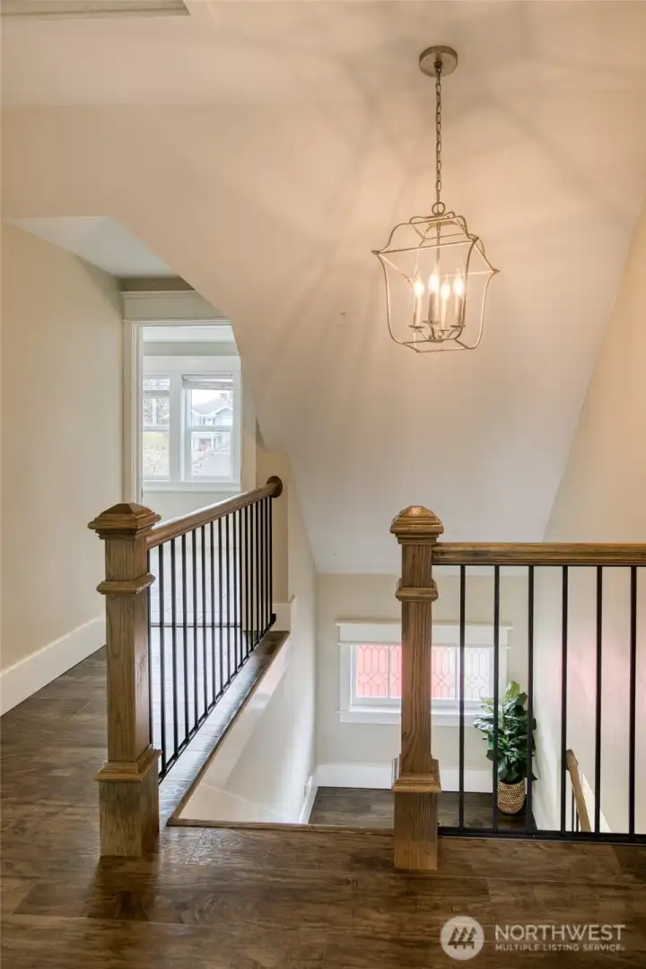 Upstairs landing with beautiful wood and iron-rod railing