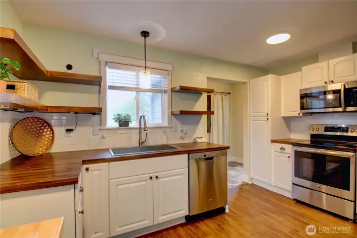 Cute kitchen with built in pantry space, newer appliances and wall of new cabinets.