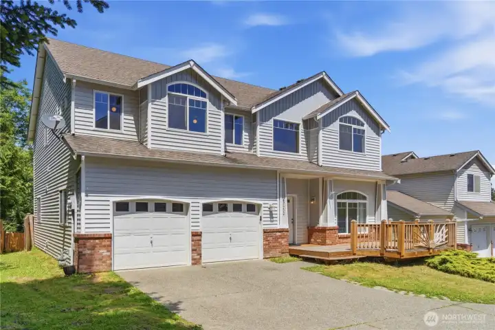 Charming curb appeal with a spacious front deck featuring decorative railings—perfect for relaxing or welcoming guests right at the entry.