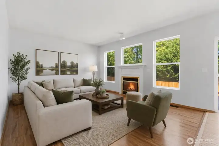 Virtual staging demonstrates a large cozy sectional perfectly situated to enjoy the fireplace or the view to the back property.
