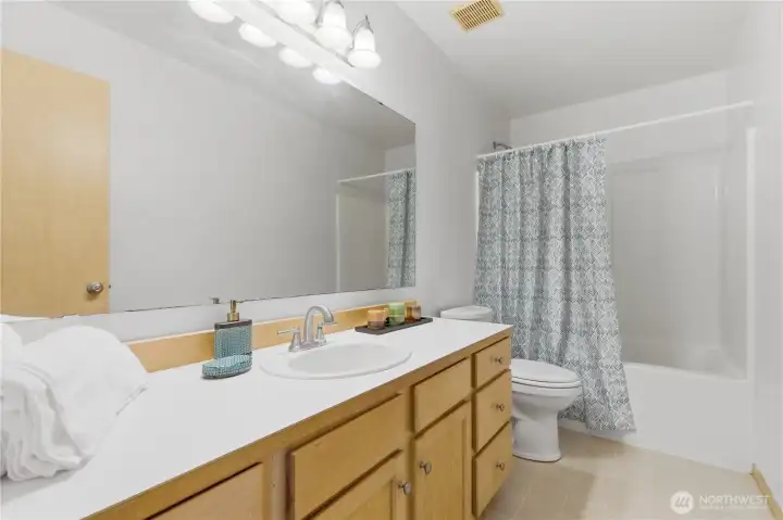 A large upstairs bath complete with tub and shower and generous cabinet storage and counter top space.